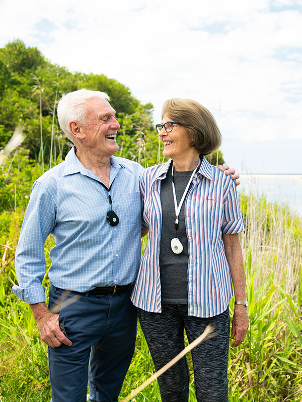 Senior couple wearing their Live Life alarm pendants walking
