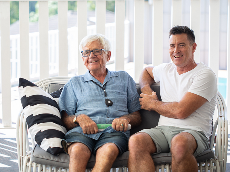 Senior wearing LiveLife personal emergency alarm pendant with family member