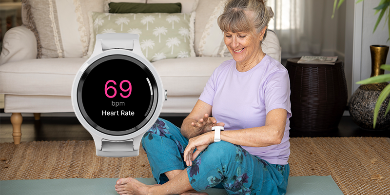Senior woman checking her LiveLife personal alarm watch at home