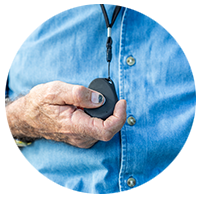 Older gentleman pressing the SOS button the pendant alarm