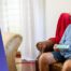 Senior in the home setting, sitting on the armchair, drinking water.