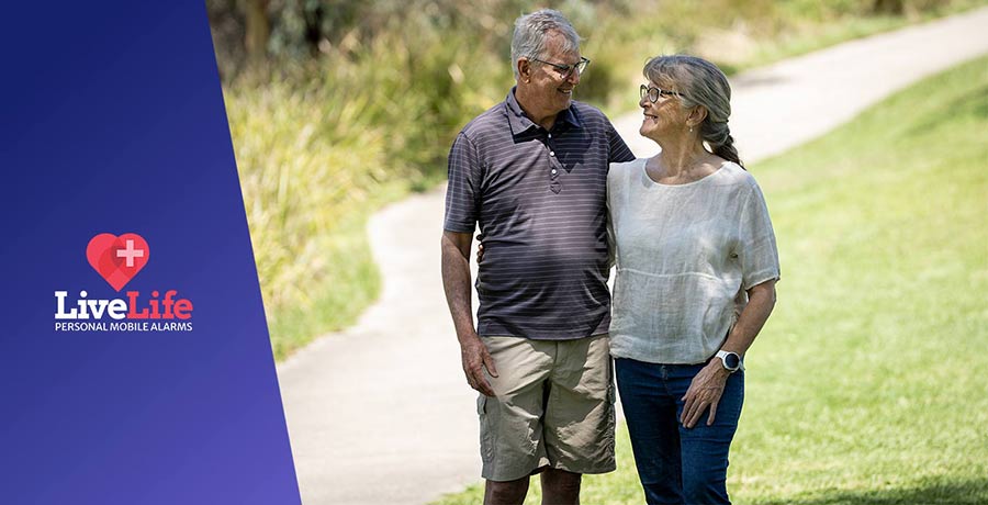 Senior couple walking at the park, wearing the LiveLife Watch