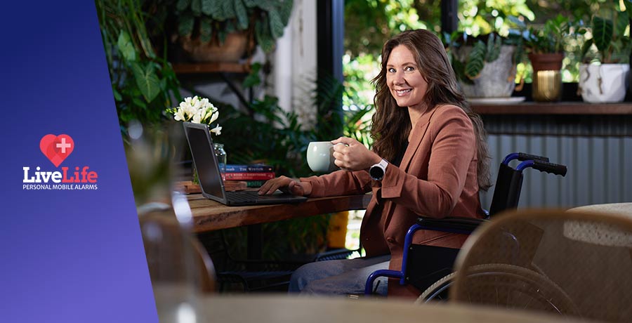 Young woman on a wheelchair, sitting on a Cafe and smiling.