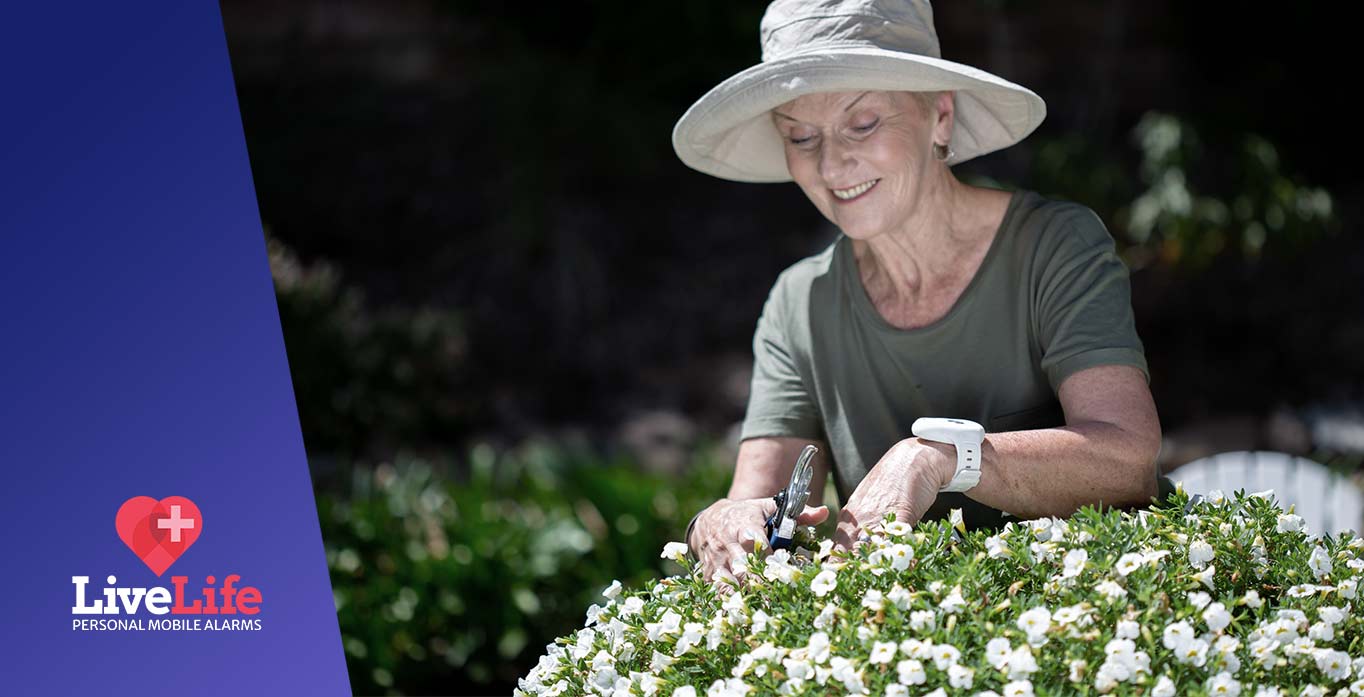 Lady gardening wearing her Live Life fall alarm pendant